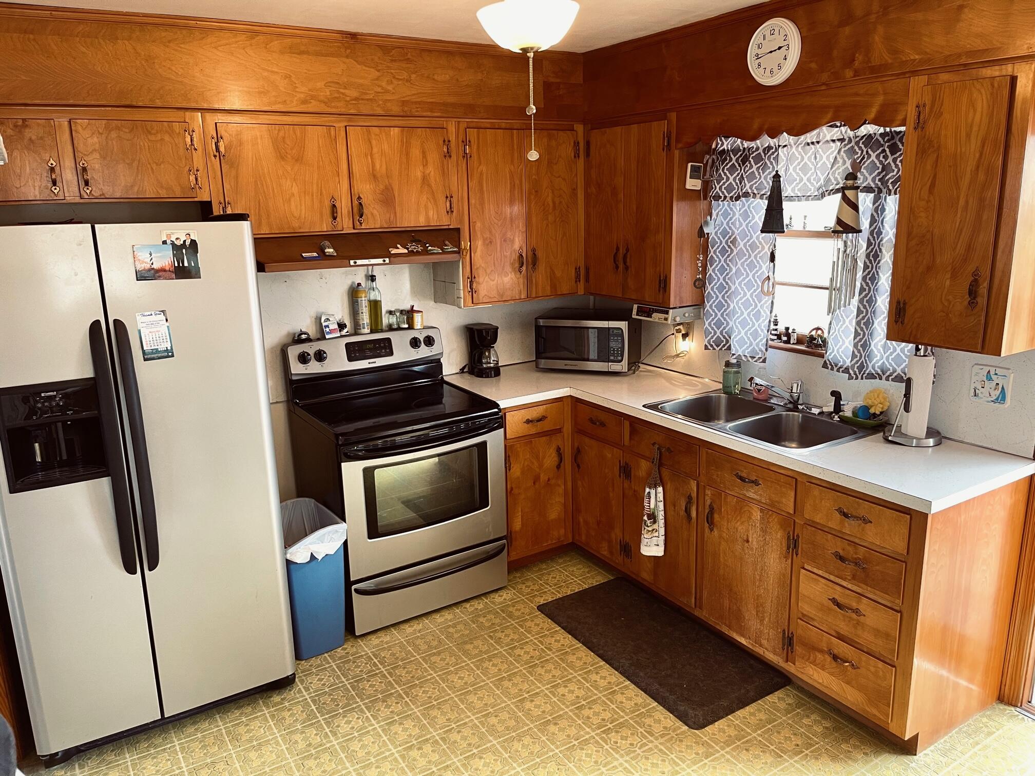516 Mapleton Avenue Northeast Roanoke, VA 24012 - Photo 15 of 21 a kitchen with stainless steel appliances a stove a refrigerator a sink a counter space and cabinets