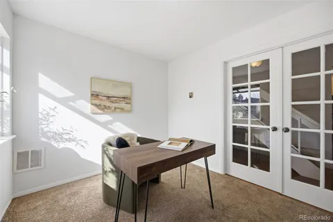 a view of a workspace with furniture and a window