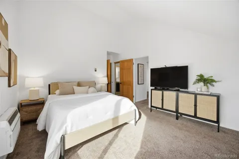 a spacious bedroom with a bed and a flat screen tv