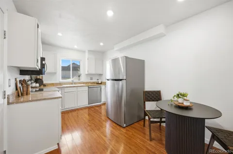 a kitchen with refrigerator cabinets and wooden floor