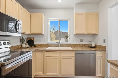 a kitchen with stainless steel appliances granite countertop a sink stove and cabinets
