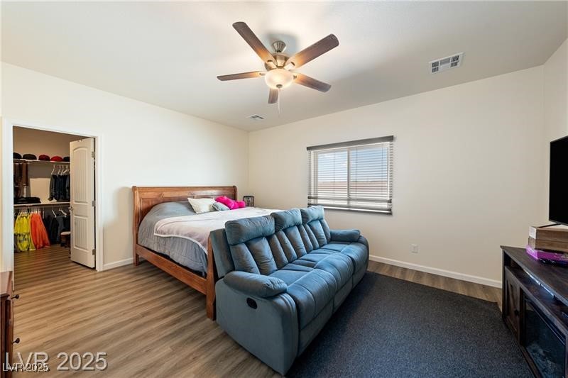 760 Fort Churchill Road Pahrump, NV 89060 - Photo 12 of 33 Bedroom featuring a walk in closet, wood finished floors, and ceiling fan