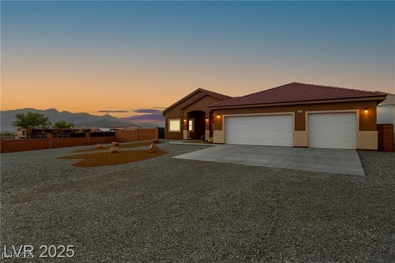 760 Fort Churchill Road Pahrump, NV 89060 - Photo 2 of 33 View of front of house featuring concrete driveway, a garage, stucco siding, and a tile roof