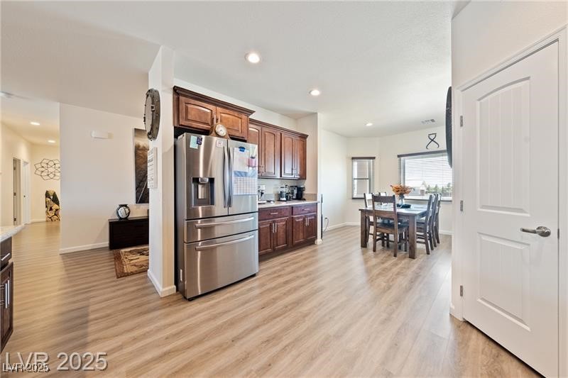 760 Fort Churchill Road Pahrump, NV 89060 - Photo 6 of 33 Kitchen with stainless steel fridge with ice dispenser, light countertops, recessed lighting, light wood finished floors, and dark brown cabinetry