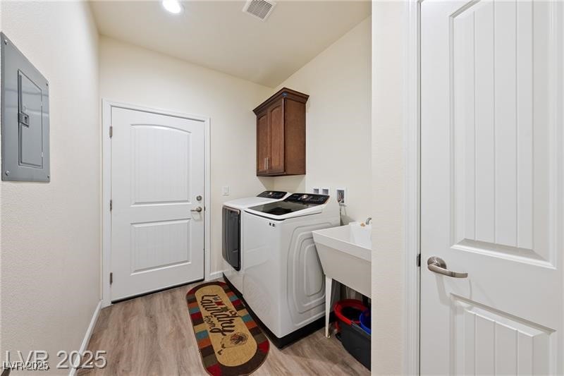 760 Fort Churchill Road Pahrump, NV 89060 - Photo 9 of 33 Washroom with electric panel, independent washer and dryer, light wood-style flooring, and cabinet space