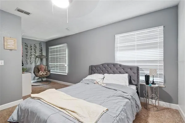 a room with lots of white furniture and a chandelier
