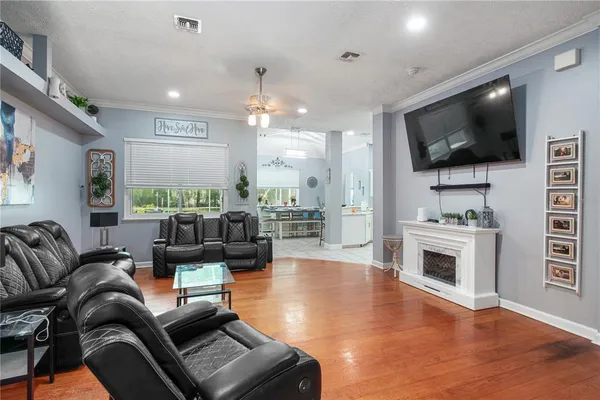 a kitchen with stainless steel appliances kitchen island granite countertop a dining table chairs and a refrigerator