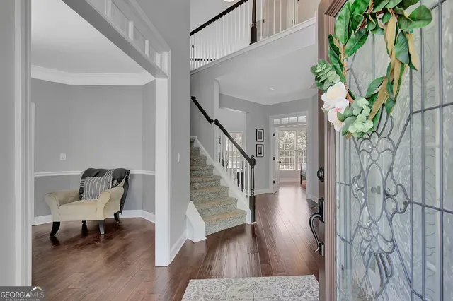 a view of staircase with wooden floor and a front door