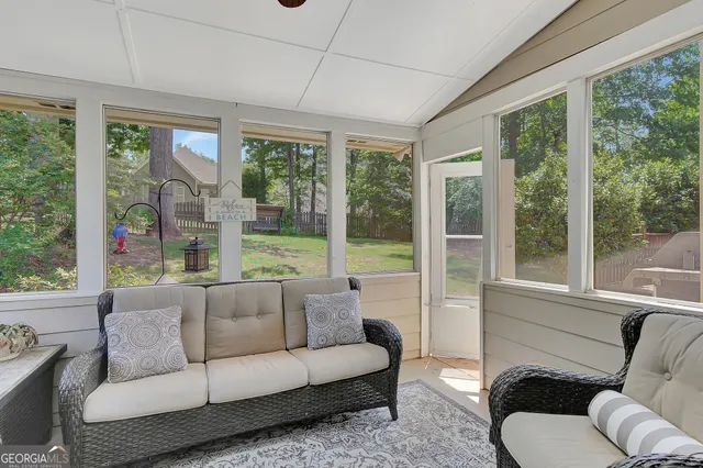 a kitchen with stainless steel appliances granite countertop a dining table chairs and white cabinets