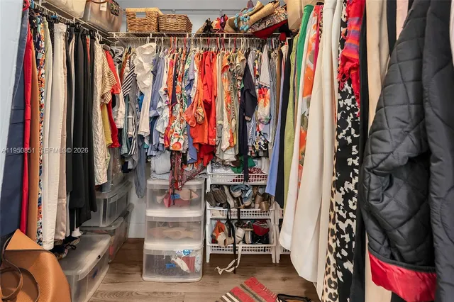 a view of walk in closet with clothes