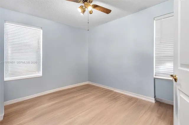an empty room with a window and wooden floor