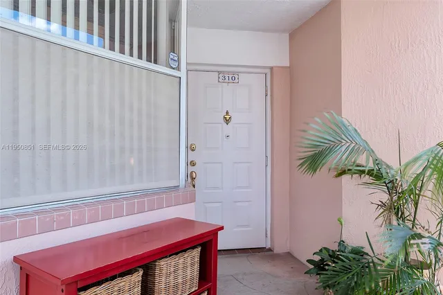 a view of a room with window and potted plants