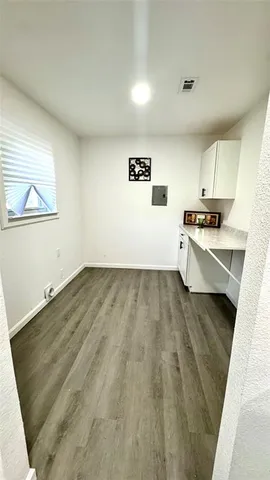 a view of a kitchen with wooden floor and electronic appliances