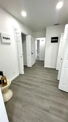 an empty room with wooden floor and mirror