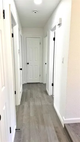 a view of a hallway with wooden floor and staircase