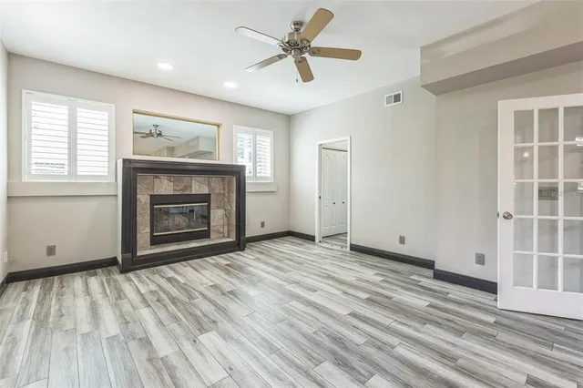 a view of a livingroom with wooden floor and a ceiling fan