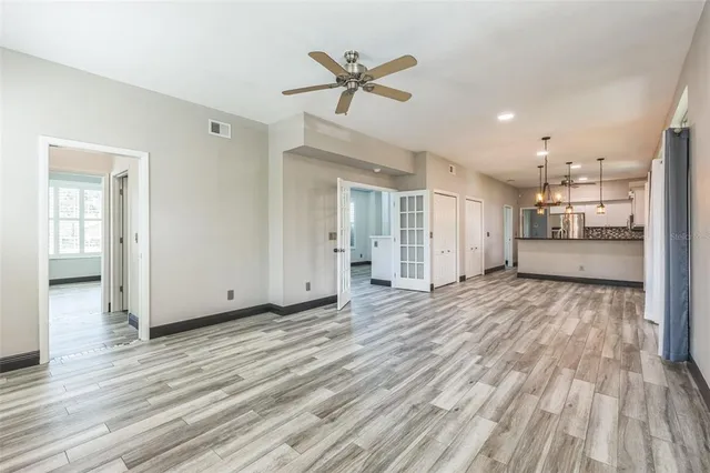 a kitchen with stainless steel appliances granite countertop a stove a sink and a granite counter tops with white cabinets next to a window