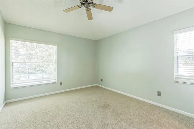an empty room with a ceiling fan and a shower