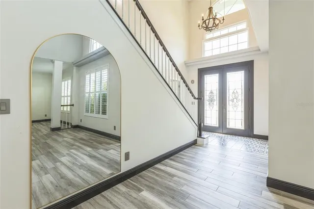 a view of a hallway with wooden floor and staircase