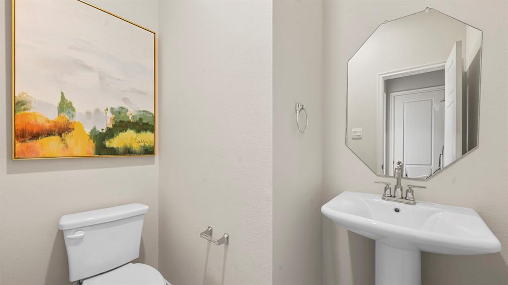 a bathroom with a toilet a sink and mirror