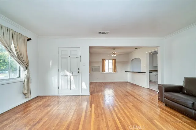 a view of empty room with wooden floor and fan