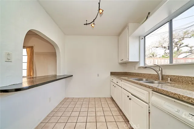 a kitchen with a sink a window and cabinets
