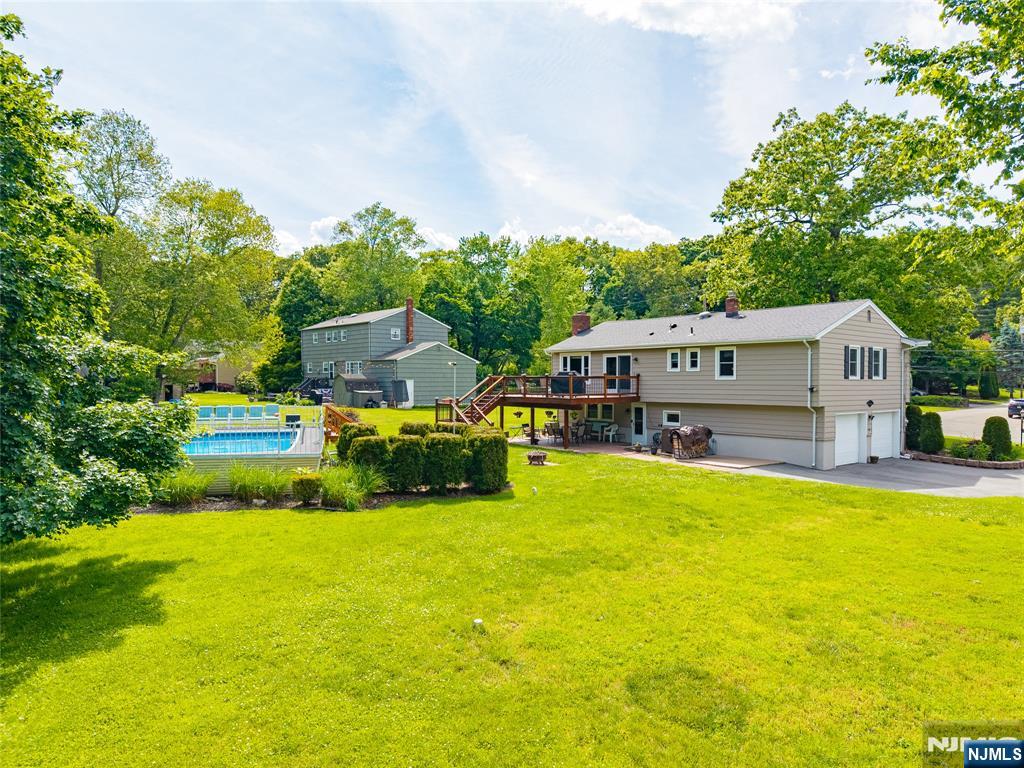 55 Marcia Road Ringwood, NJ 07456 - Photo 39 of 42 a view of a house with a big yard potted plants and large tree