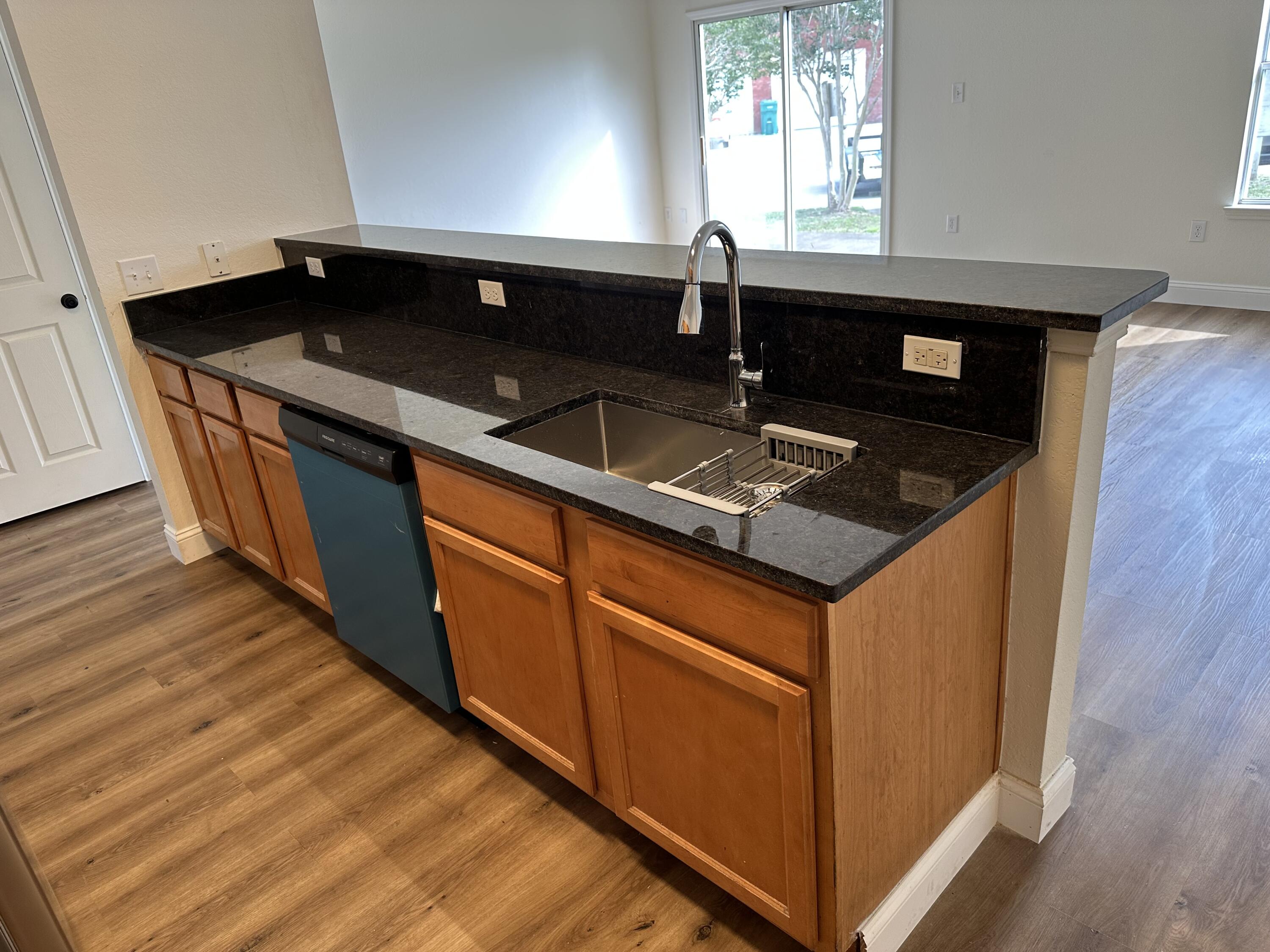 1150 Airport Road, Unit 138 Destin, FL 32541 - Photo 3 of 16 a kitchen with stainless steel appliances granite countertop a sink stove and wooden floor