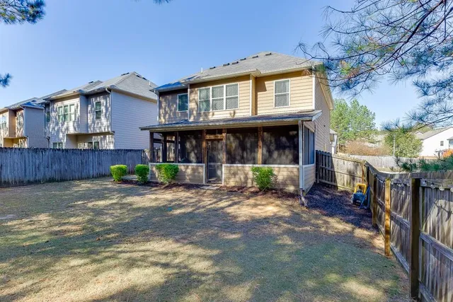 a view of a house with a yard and wooden fence