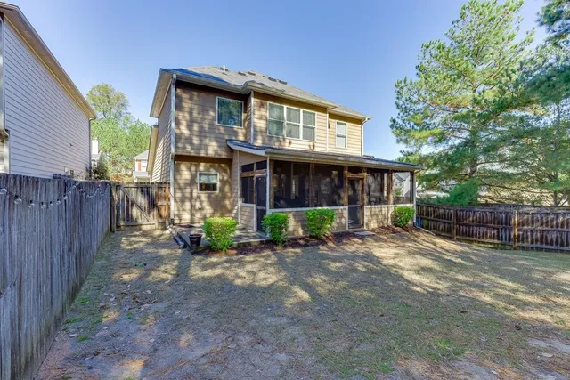 a view of a house with a yard and wooden fence