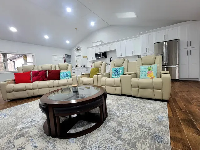 a living room with furniture and kitchen view