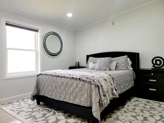 a bed sitting in a bedroom next to a window