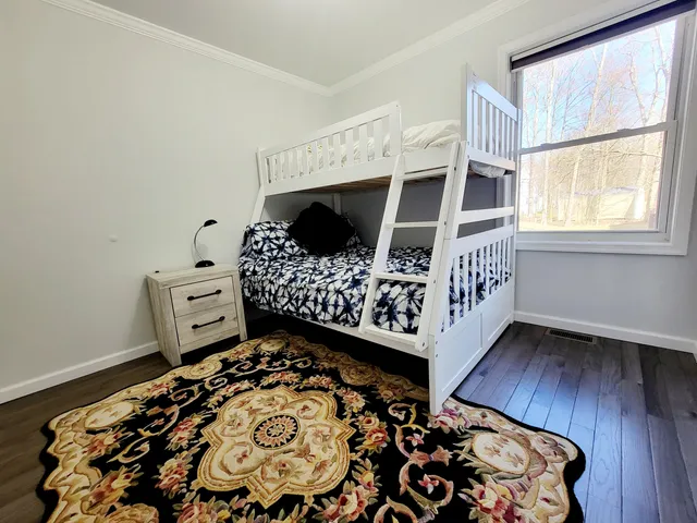 a bedroom with a bed and wooden floor