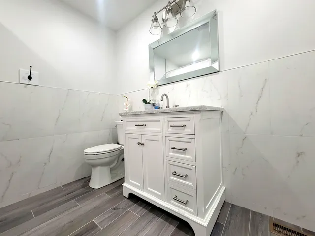 a bathroom with a toilet a sink and mirror