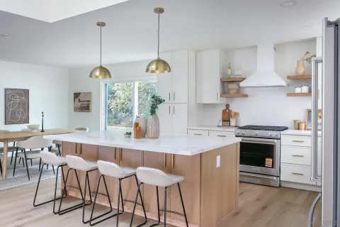 a kitchen with stainless steel appliances granite countertop a stove a sink dishwasher and a refrigerator with wooden floor