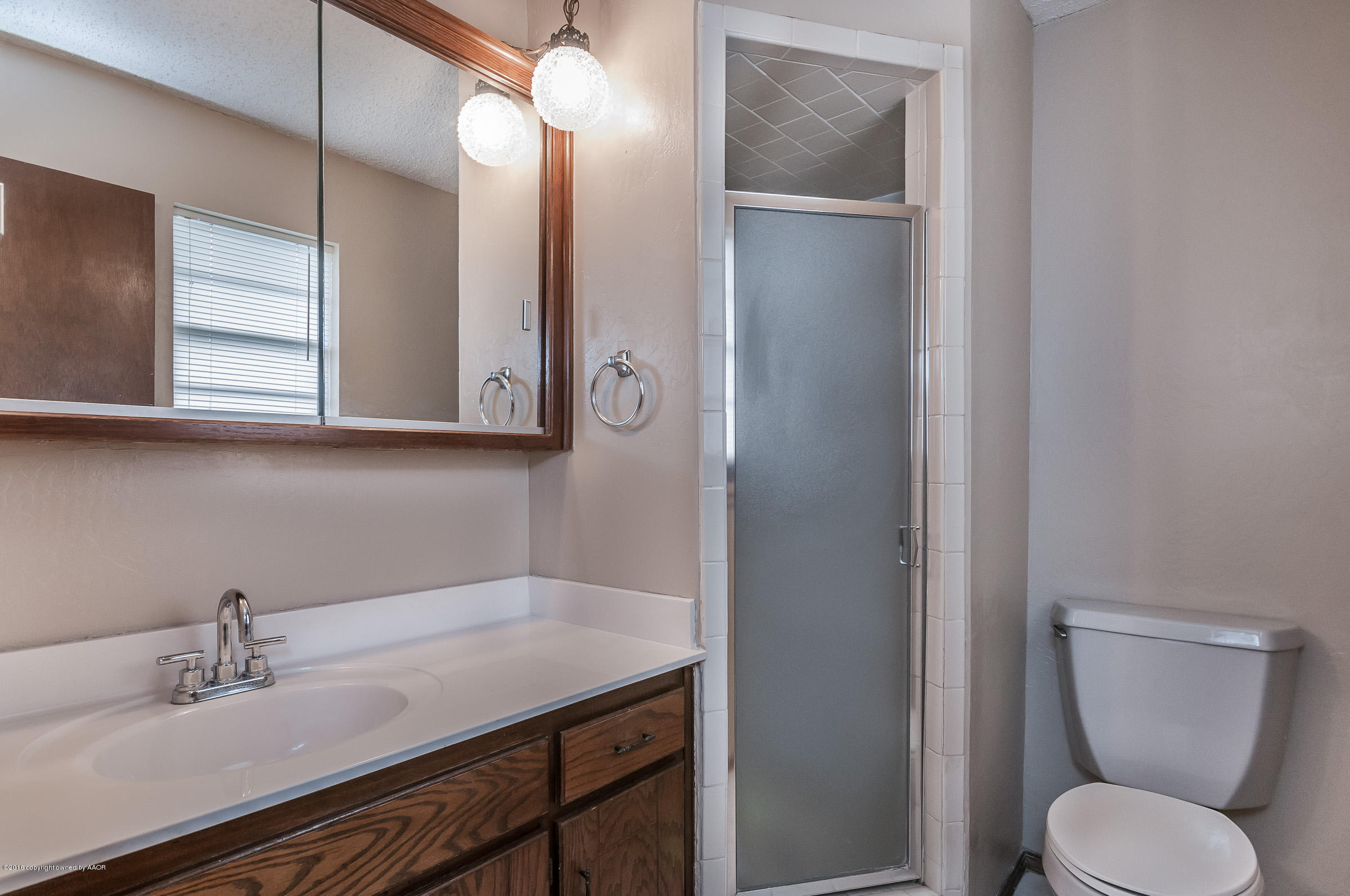 5312 Wheeler Lane Amarillo, TX 79110 - Photo 13 of 20 a bathroom with a toilet sink and mirror
