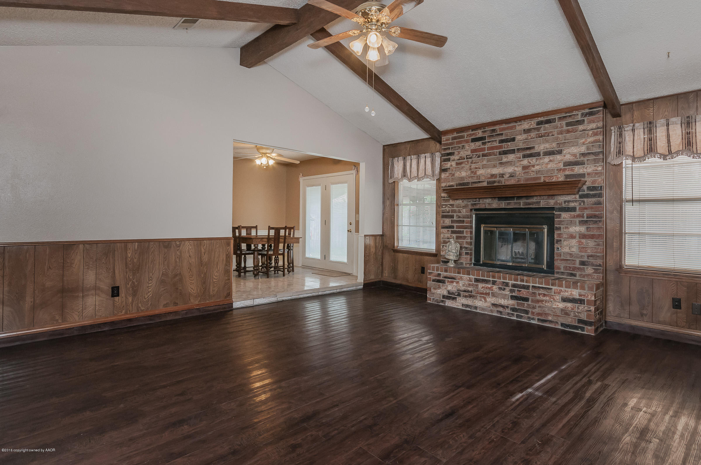 5312 Wheeler Lane Amarillo, TX 79110 - Photo 5 of 20 an empty room with wooden floor fireplace and windows