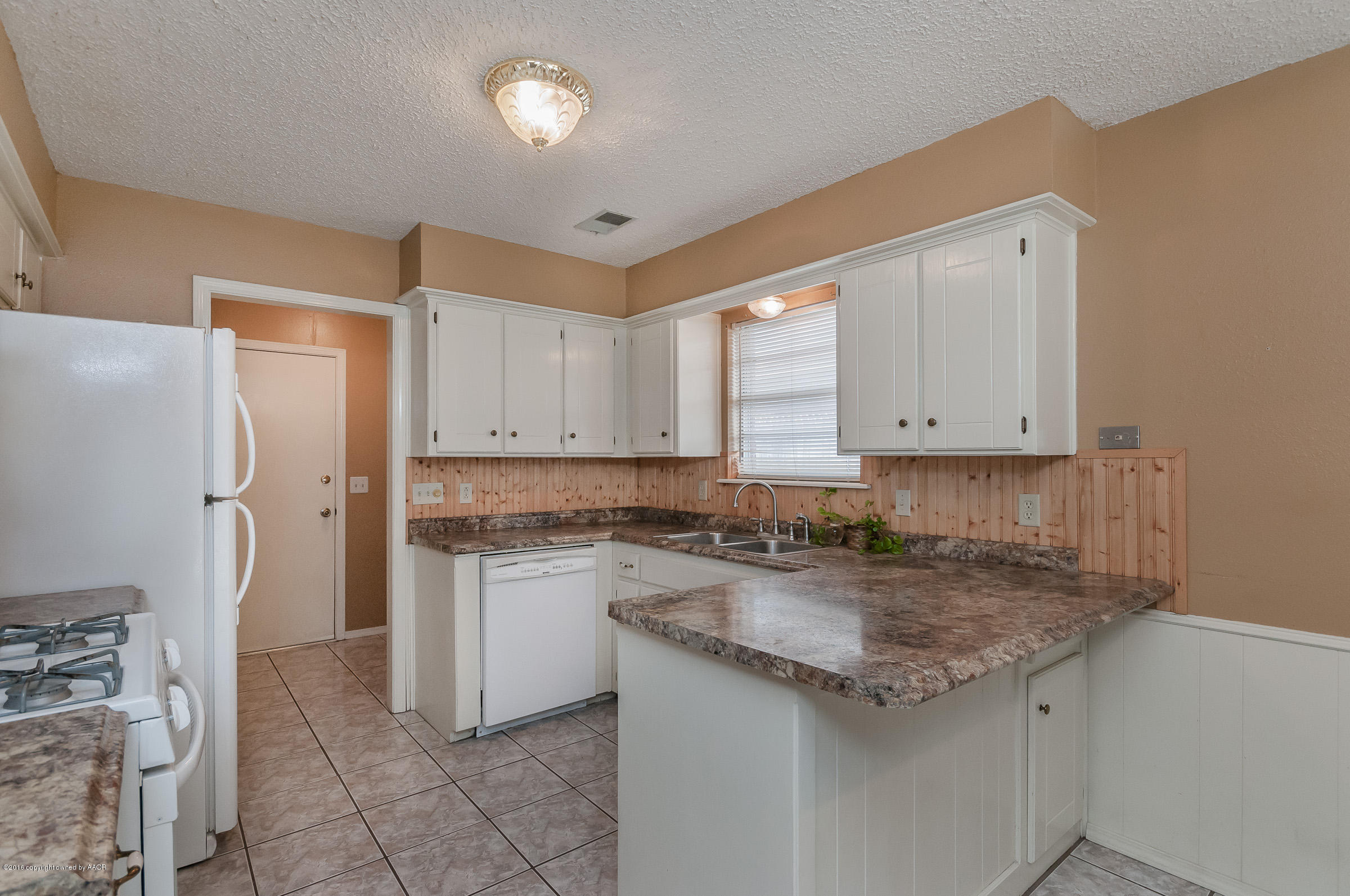 5312 Wheeler Lane Amarillo, TX 79110 - Photo 9 of 20 a kitchen with a sink a stove a refrigerator and cabinets