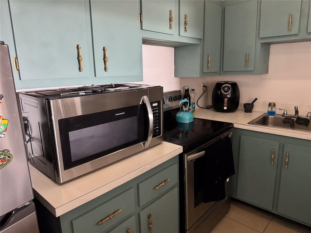 4174 Inverrary Drive, Unit 905 Lauderhill, FL 33319 - Photo 5 of 23 a kitchen with a stove microwave and sink
