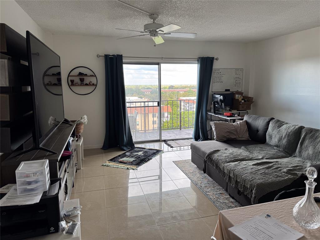4174 Inverrary Drive, Unit 905 Lauderhill, FL 33319 - Photo 7 of 23 a living room with furniture a flat screen tv and a window