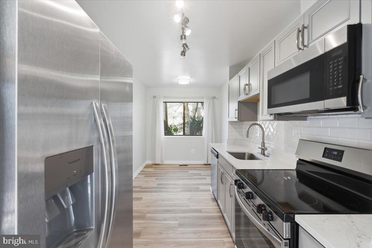 11919 Barrel Cooper Court Reston, VA 20191 - Photo 8 of 39 a kitchen with stainless steel appliances granite countertop a sink stove and microwave