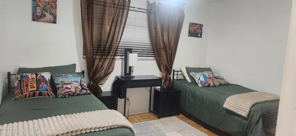 a view of a hallway to room with wooden floor