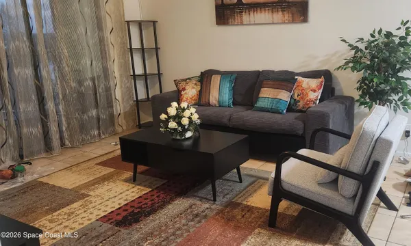 a living room with furniture and a potted plant