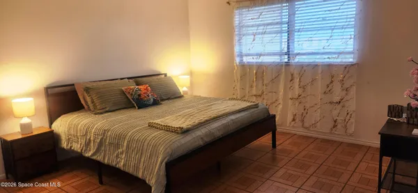 a bedroom with a bed and a window