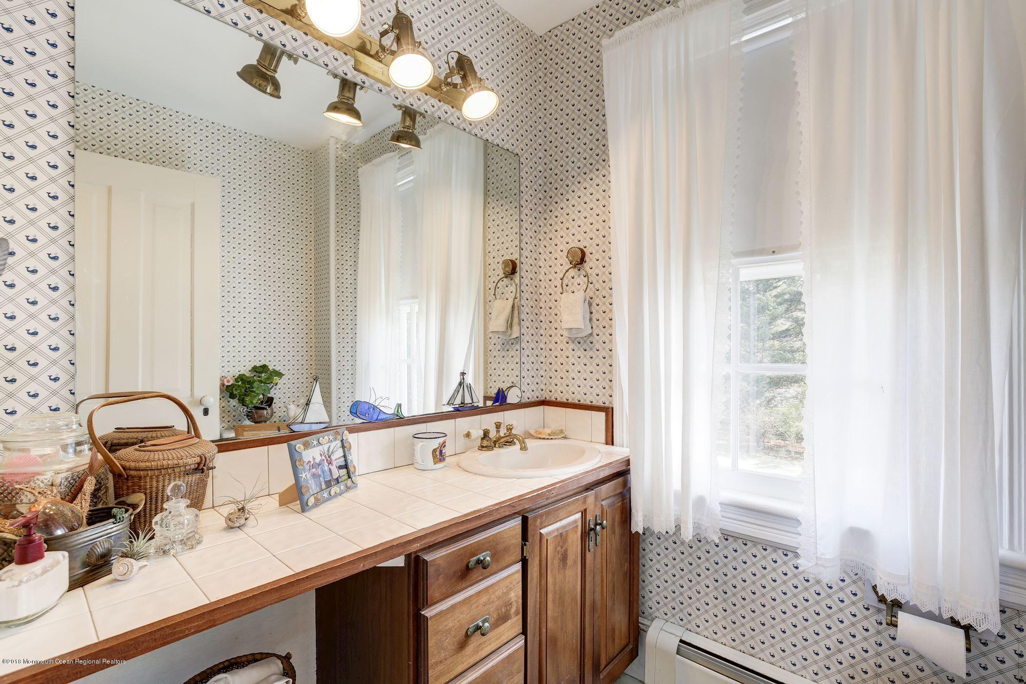 19 Tilton Road Middletown, NJ 07748 - Photo 20 of 26 a bathroom with a double vanity sink a mirror and a bathtub