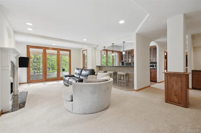a living room with furniture a large window and kitchen view