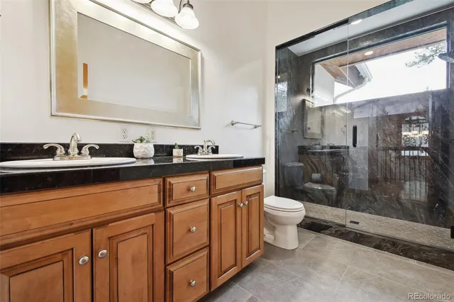 a bathroom with a double vanity sink toilet and shower