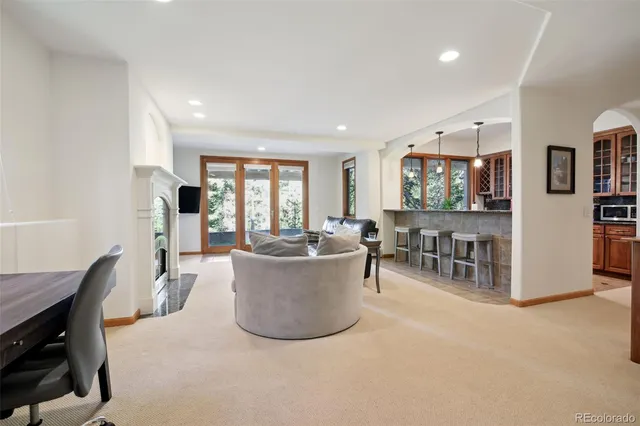 a living room with furniture a large window and dining table