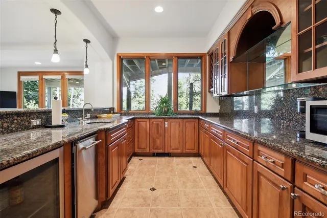 a large kitchen with stainless steel appliances granite countertop a stove a sink dishwasher and a large oven with wooden cabinets