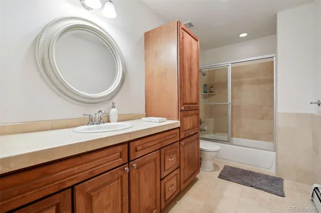 a bathroom with a granite countertop sink a toilet and a mirror